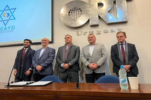 Los cinco candidatos a la Presidencia de pie junto a la mesa de firma, frente al logo de FICAYD